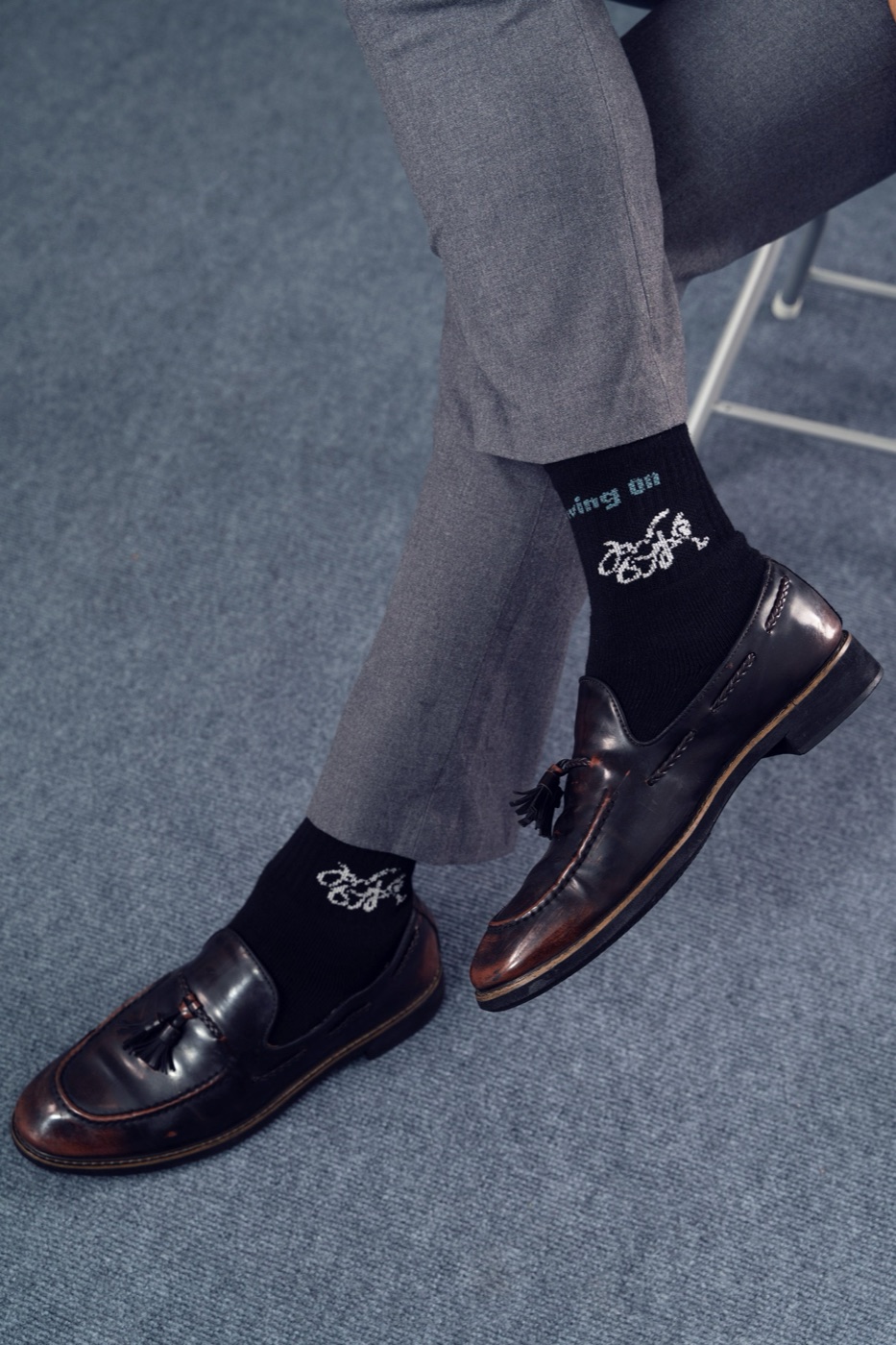 Black Micro Crew socks with tassel loafers, legs crossed.