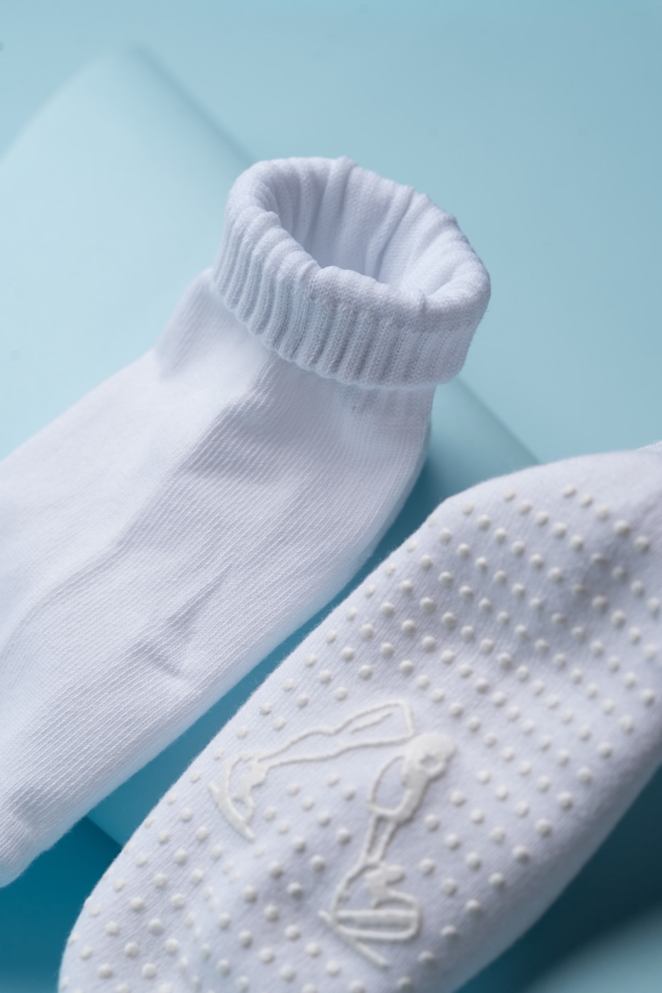 Close-up of the kid's sock anti-slip sole — the grip dots form the walking-legs logo.